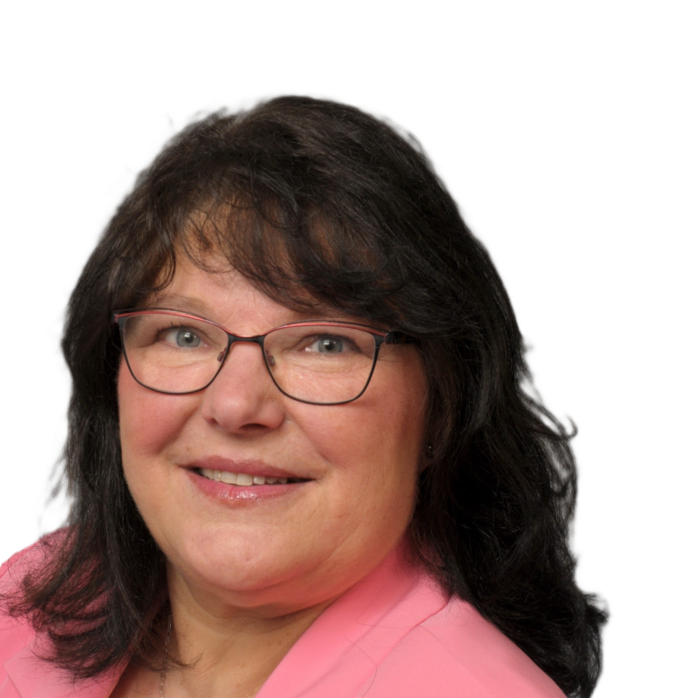 Porträt einer lächelnden Frau mit Brille, dunklem Haar und rosa Oberteil.